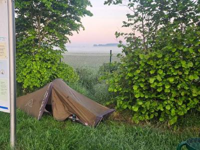 My pitch on day eight. Another one that was just a few feet from the country lane I was following. A small one man tent on a patch of grass behind an info sign. Misty fields are in the background.