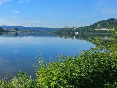 Looking out over the Rhur reservoir in Herdecke, Nordrhein-Westfalen Wide calm reservoir reflecting blue sky, with wooded hills and buildings on shore.